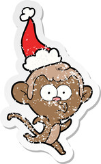 distressed sticker cartoon of a surprised monkey wearing santa hat