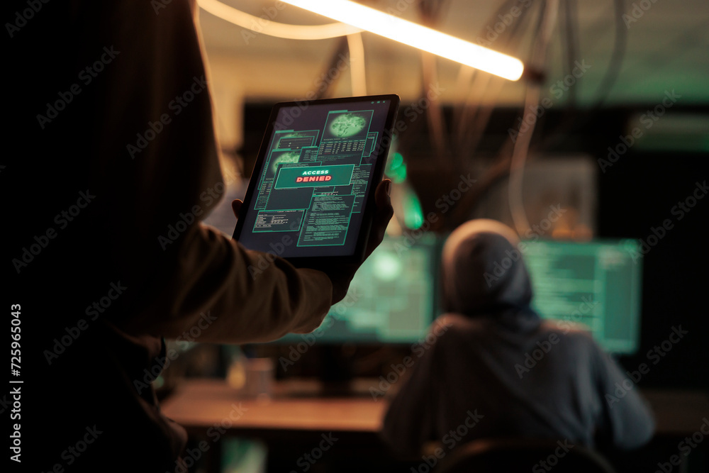 Poster thief reading access denied message on tablet, hacker failing to crack firewall encrytion and steal 
