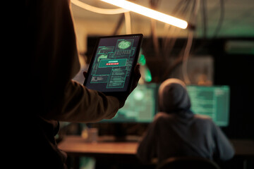 Thief reading access denied message on tablet, hacker failing to crack firewall encrytion and steal data. Internet criminal using malicious software, to break and crack passwords.