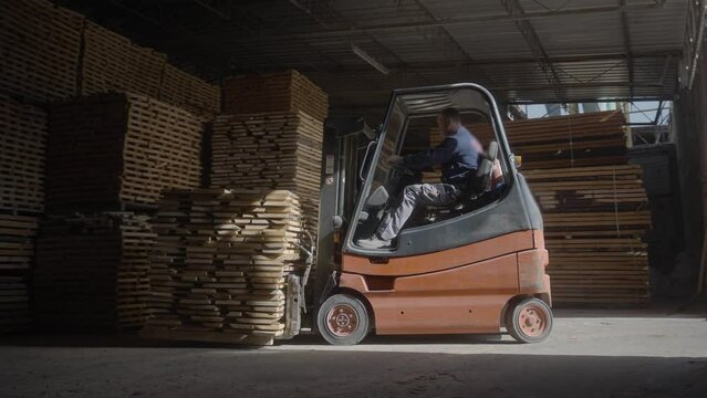 Forklift driver working in big warehouse
