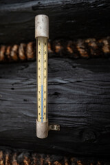 Outdoor plastic mercury thermometer on wood.