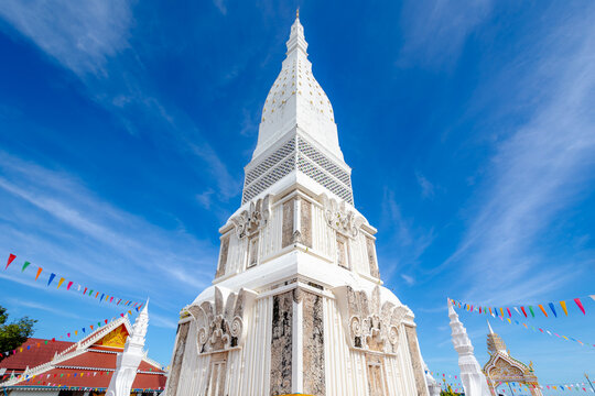 White gold pagoda with blue sky and white cloud background, Wat Phrathat Tha Uthen is a Buddhist temple in the Tha Uthen District, Nakhon Phanom Province, Isan region of Thailand near the Lao border.