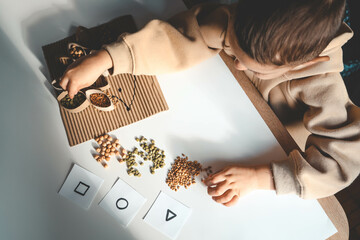 Montessori and Sensory Development, A child plays with natural materials and sorts cereals