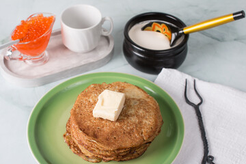 Maslenitsa holiday, pancakes with sour cream on the table. The Russian tradition