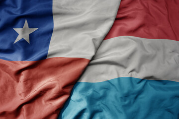 big waving national colorful flag of luxembourg and national flag of chile .