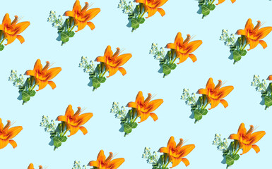 Orange lily, creative floral pattern, spring garden flowers on a pastel blue background.