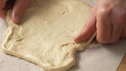 Stretching Pizza Dough on Table. Close-up, shallow dof.