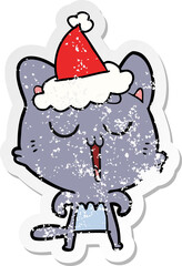 distressed sticker cartoon of a cat singing wearing santa hat