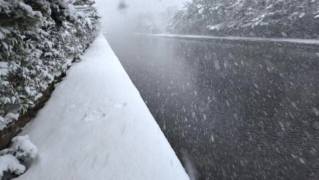 Walking into heavy snow by waterway in white winter landscape