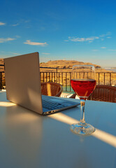 Laptop and a glass of wine. An ideal place for remote work.