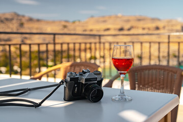 Retro camera and glass of red wine on the table.