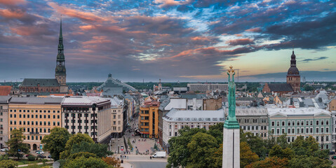 Naklejka premium Beautiful sunrise view over Riga by the statue of liberty - Milda in Latvia. The monument of freedom.