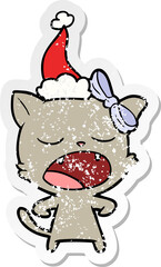 distressed sticker cartoon of a yawning cat wearing santa hat