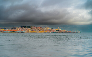 A panoramic perspective of Lisbon. The sea in the foreground. cloudy sky.