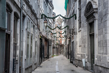 Selective blur on Rue de la Goffe, a pedestrian street of the city center of Liege, with facades of old buildings and shops and boutiques in belgium. - obrazy, fototapety, plakaty