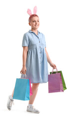 Young woman with bunny ears and shopping bags on white background. Easter celebration