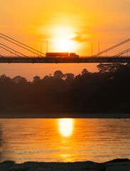 Golden sunset near a river and a bridge
