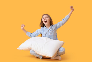 Sleepy little girl with pillow on yellow background