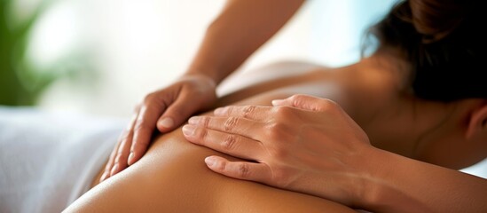 Therapist provides deep tissue massage for woman's shoulder.