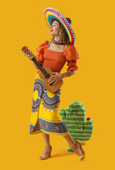 Pretty young woman in sombrero on yellow background