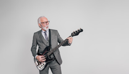 Portrait of confident senior male professional plucking electric guitar on isolated white background