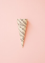Ice cream cone wrapped in decorative paper with musical notes. Pastel background. Minimal creative...