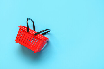 Small red shopping basket on blue background