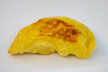 Traditional Ukrainian pierogi grilled in butter and served with minced meat and cream, decorated with fresh fine herbs