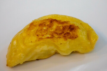 Traditional Ukrainian pierogi grilled in butter and served with minced meat and cream, decorated with fresh fine herbs