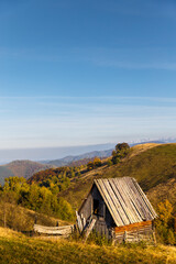 Small old wooden abandoned shepherds house on hill against mountain landscape. Carpathian...