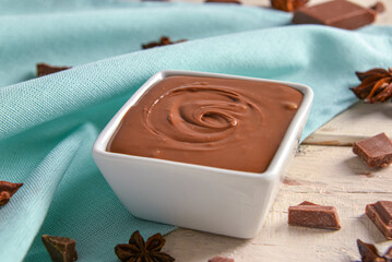 Composition with tasty melted chocolate on white wooden background