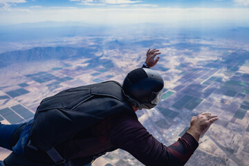 Skydiver in freefall from behind over the desert