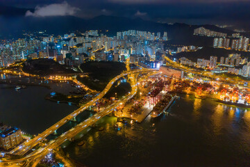 Fototapeta na wymiar Aerial top view of container cargo ship in the export and import business and logistics international goods in urban city. Shipping to the harbor by crane in Victoria Harbour, Hong Kong City at night.