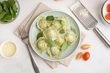 Plate of tasty ravioli with cheese on white background
