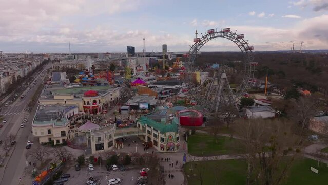 Fly around large historic Ferris Wheel and other attractions in Prater amusement park. Vienna, Austria