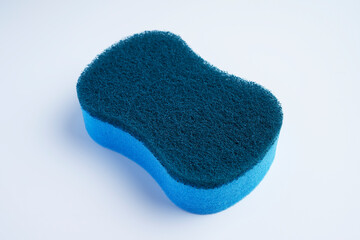 A blue dishwashing scrubber made with different materials on the top and bottom