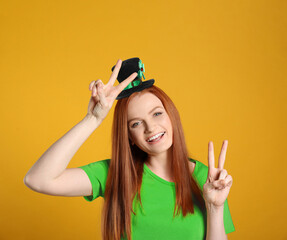 St. Patrick's day party. Pretty woman in leprechaun hat on golden background