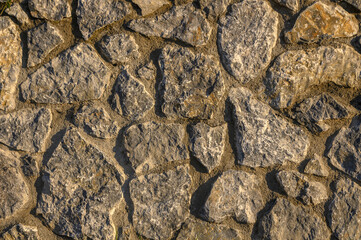 wall made of real stone as a background in the sun 7
