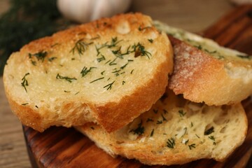 Tasty baguette with garlic and dill on table, closeup