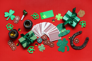Composition with poker chips, cards and decorations for St. Patrick's Day celebration  on red background