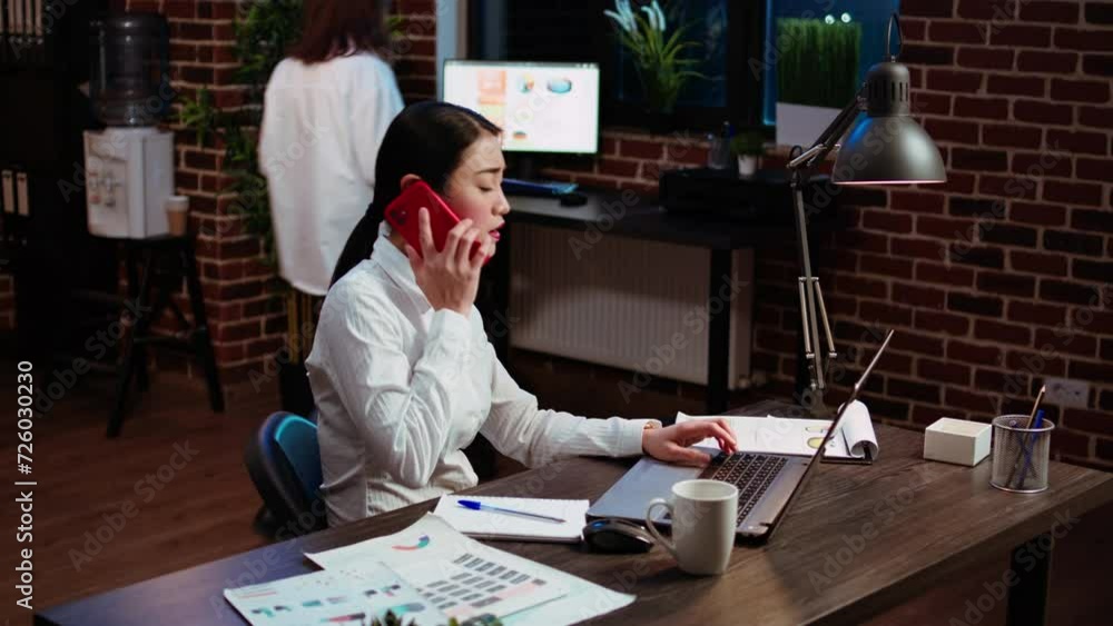 Poster stressed businesswoman doing multitasking, answering phone while crosschecking data between laptop a