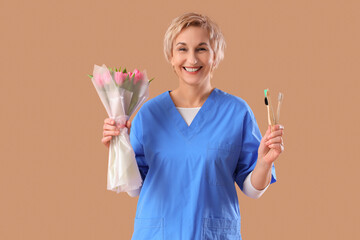 Mature female dentist with tulips and toothbrushes on brown background. International Women's Day celebration