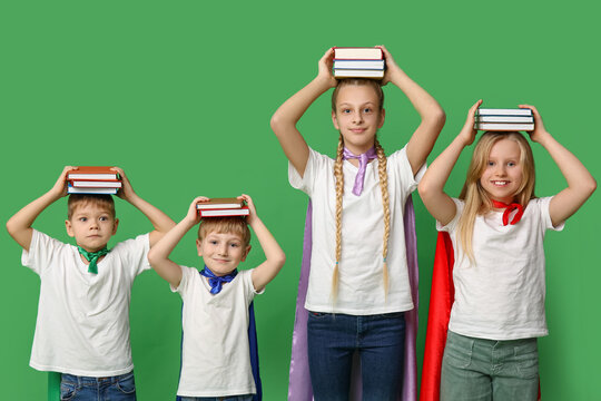 Cute kids dressed as superhero with books on green background. Library Lovers Day