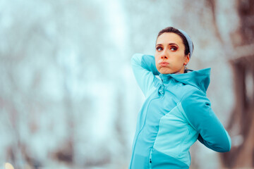 Tired Woman Stretching her Arms preparing for Jogging Session. Jogger ready to work out outdoors in...