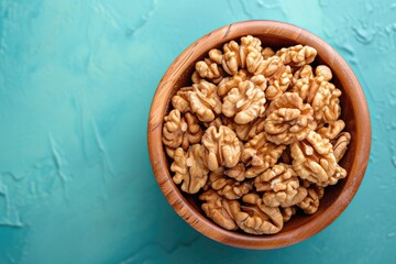 Close up of walnut halves in a wooden bowl on a colored background Promoting healthy eating and...