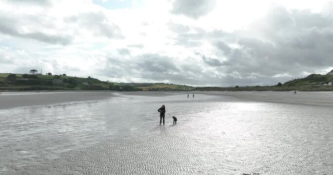 Mother and child on a deserted beach on a cold day