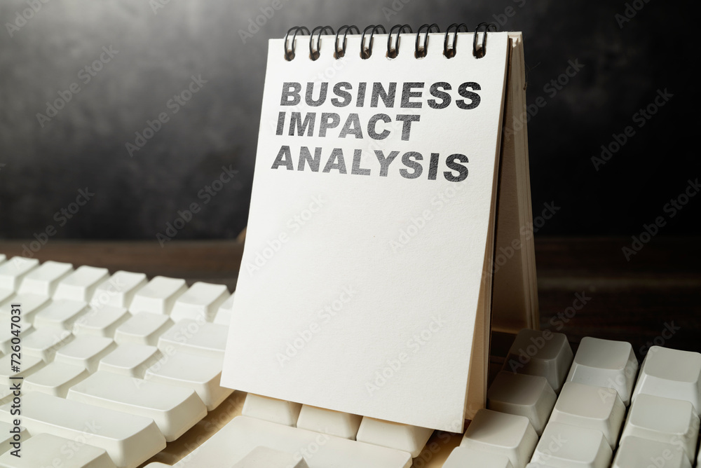 Poster notes with the text of business impact analysis on the keyboard
