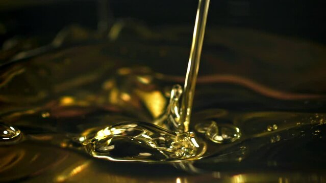Olive oil with splashes on black background. Filmed on a high-speed camera at 1000 fps. High quality FullHD footage