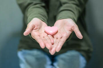 Pink heart shape in woman's hand