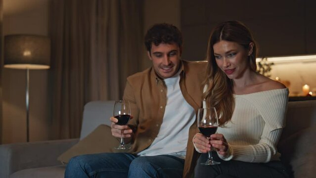 Young pair first date in romantic apartment. Happy couple sitting cozy couch